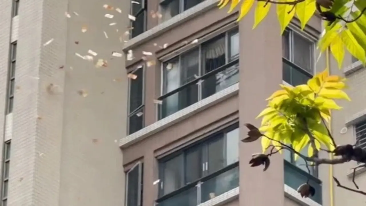 Người phụ nữ Trung Quốc ném tiền từ chung cư xuống, mọi người tranh nhặt